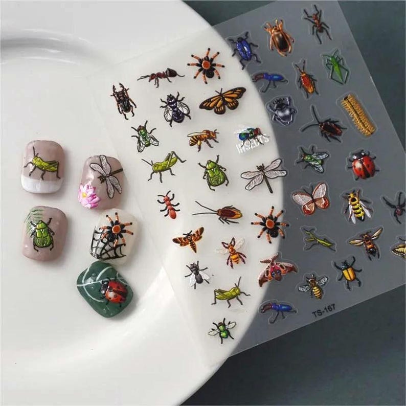 May include: A sheet of clear nail art stickers with a variety of colorful insect designs, including butterflies, ladybugs, beetles, and ants. The sheet is labeled "TS-167".