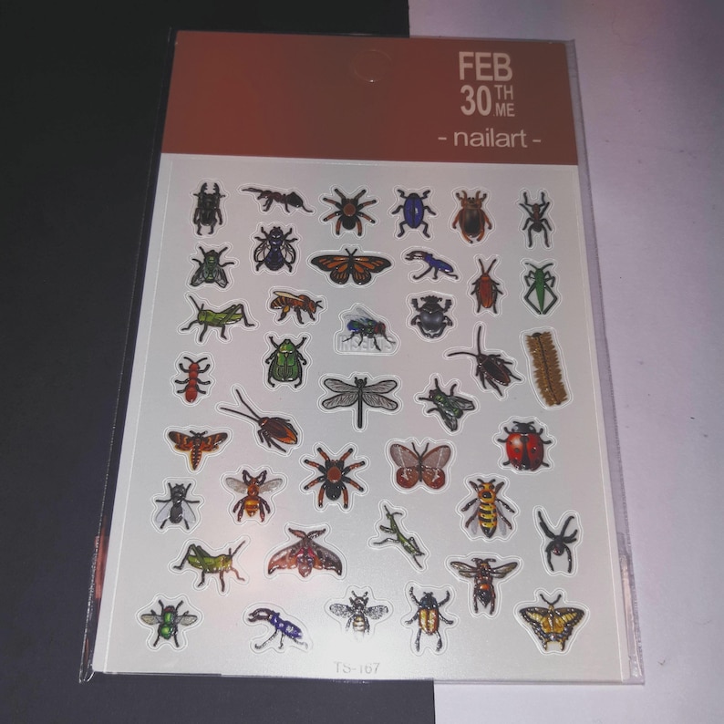 May include: A sheet of nail art stickers featuring a variety of insects, including butterflies, ladybugs, beetles, and dragonflies. The stickers are on a white background with the text "FEB 30TH WE - nailart - TS-107".
