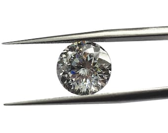 May include: A clear round diamond gemstone held by silver tweezers.