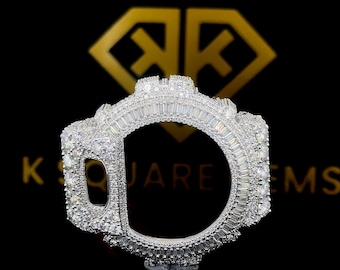 Könnte beinhalten: Eine silberfarbene Lünette mit zahlreichen kleinen, klaren Edelsteinen besetzt. Die Lünette hat eine rechteckige Form mit einer großen, offenen Mitte. Die Worte "K SQUARE GEMS" stehen in goldener Schrift darüber.