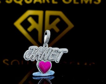 May include: A silver pendant with a pink heart charm and the word "AMOUR" spelled out in diamonds.