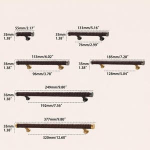 May include: A white ceramic mug with a black handle and the text "But First, Coffee" in a black, bold font. The mug is sitting on a wooden surface. The mug is likely used for drinking coffee or tea.