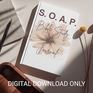 Puede incluir: Un "S.O.A.P. Bible Study Journal" blanco con un diseño floral, un cuaderno gris, un lápiz y una bandeja de madera están dispuestos sobre una superficie blanca. Las palabras "DIGITAL DOWNLOAD ONLY" están impresas en la parte inferior de la imagen.