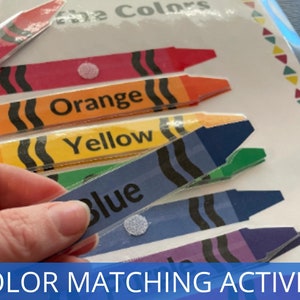 Pode incluir: Uma atividade de correspond&ecirc;ncia de cores para crian&ccedil;as com um conjunto de pe&ccedil;as em forma de giz de cera coloridas com as palavras "Vermelho", "Laranja", "Amarelo", "Azul", "Verde" e "Roxo" impressas nelas.