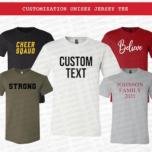 May include: Five different t-shirts with various text designs. The shirts are in different colors, including black, white, red, green, and gray. The text on the shirts includes "Cheer Squad", "Strong", "Custom Text", "Believe", and "Johnson Family 2021".