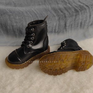 May include: A pair of black leather ankle boots with laces and a thick rubber sole. The boots have a classic style and are perfect for everyday wear.