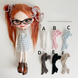 Pode incluir: Uma boneca com cabelo ruivo, óculos e um vestido xadrez azul e branco é exibida com seis pares de meias de boneca em várias cores: branco, rosa, azul claro, cinza, preto e bege. O texto "blythe/ob22/ob24/landoudou" é visível.