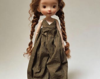 May include: A handcrafted doll with auburn hair styled in two long braids. The doll wears a brown jumpsuit and matching brown shoes. The doll has a fair complexion and is posed against a neutral background.