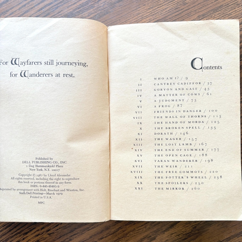 The image shows a table of contents for the book "Taran Wanderer" with a dedication on the left page. The table of contents on the right page lists chapter titles beginning with "Who Am I?".