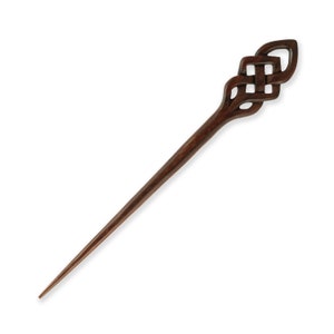 Könnte beinhalten: Ein dunkelbrauner Holzhaarstecker mit einem keltischen Knotendesign an der Spitze.