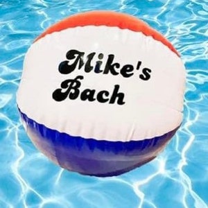 May include: A red, white, and blue inflatable beach ball with the text "Mike's Bach" in black.