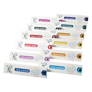May include: A set of 10 colour cards with the names of different colour seasons: Bright Winter, Dark Winter, True Winter, Dark Autumn, True Autumn, Soft Autumn, Light Spring, True Spring, Soft Summer, Light Summer, and True Summer.