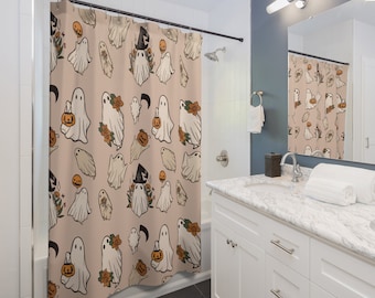 May include: A shower curtain with a pattern of white ghosts holding pumpkins and wearing witch hats on a light peach background.