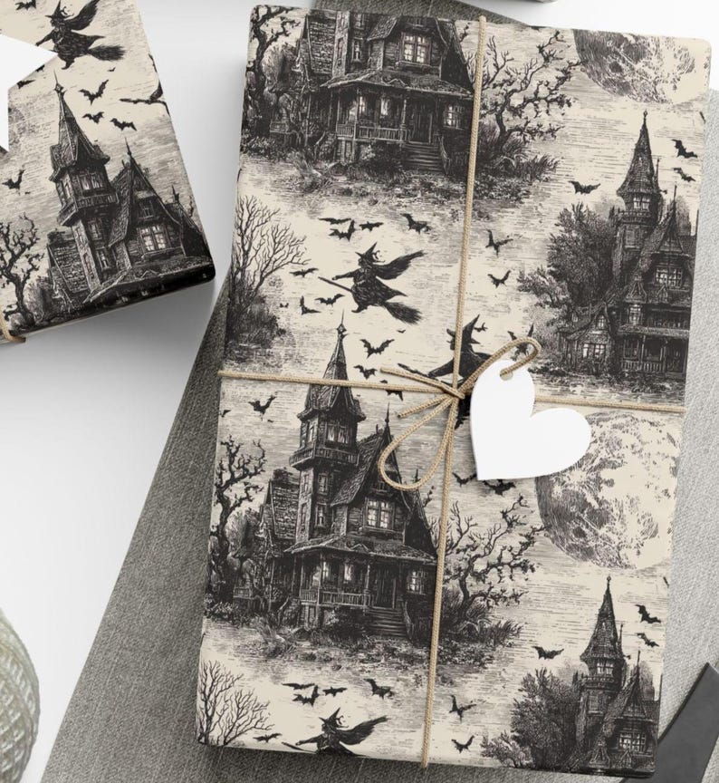 Vintage Halloween wrapping paper featuring haunted houses, flying bats, and full moon on an aged parchment cream background, tied with twine and heart tag
