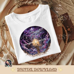 Könnte beinhalten: Ein weißes T-Shirt mit einer kreisförmigen Grafik einer kosmischen Szene mit violetten und blauen Nebelwolken, Sternen und zwei ausgestreckten Händen, eine skelettartig und eine baumartig, mit dem weißen Schriftzug AS ABOVE SO BELOW.