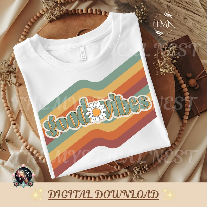 Retro "Good Vibes" design displayed on a white t-shirt mockup featuring vintage rainbow stripes in muted boho colors with a daisy flower accent. Styled on a neutral boho background with wooden beads and dried florals. Bottom banner reads "Digital Download" with The Mystical Nest branding.