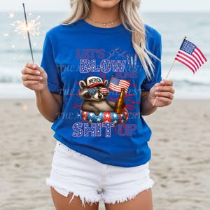 USA PNG image with a 4th of July theme digital download. The design features a cute racoon laying in a pool float holding a beer and an American flag with a hat that says merica. With red, white, and blue text that says lets blow some shit up, referring to fireworks. Same color fireworks surrounding image, perfect for Independence Day celebrations.