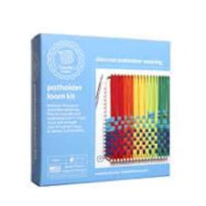 May include: A light blue box labelled "Potholder Loom Kit" with a colourful woven potholder displayed on the front. The potholder features red, orange, yellow, green, and blue threads. The box also includes text about the kit.