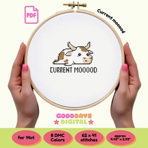 May include: Cross-stitch pattern featuring a cartoon cow with the text "CURRENT MOOOOD" in a wooden embroidery hoop. The design includes a PDF icon and the text "GOODDAYS DIGITAL". The finished design is approximately 4.43" x 2.93".