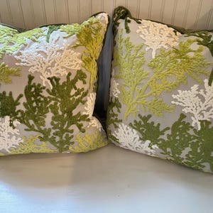May include: Two square throw pillows featuring a light gray base fabric with raised, textured embroidery in shades of white, lime green, and dark forest green. The embroidery depicts a dense, branching coral or seaweed pattern across the surface.