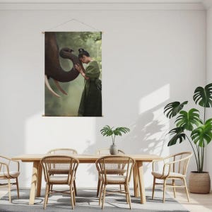 May include: A wall hanging featuring a serene image of a person in a green dress interacting with an elephant. The elephant's trunk gently touches the person's head. The background is a soft, blurred forest scene.