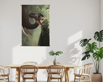 May include: A wall hanging depicting a person in a green dress and an elephant. The elephant's trunk is touching the person's head. The background is a soft, blurred forest scene. The image is suspended from a wooden rod.