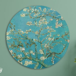 May include: A round wall art print featuring a painting of a blooming almond tree with white flowers against a blue sky. The painting is in the style of Vincent van Gogh.