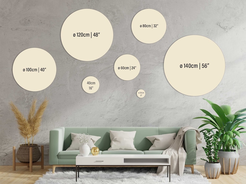 May include: A living room interior with a green sofa and a white coffee table. Five round beige wall decor pieces are displayed on the wall behind the sofa. The wall decor pieces are labelled with their diameter in centimetres and inches.