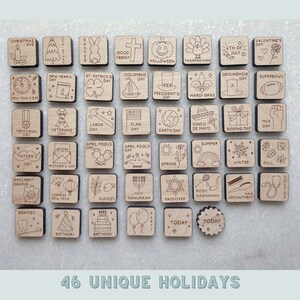 May include: A set of 46 wooden squares with different holiday icons and text. The squares are arranged in a grid pattern and are all made of light brown wood. The icons are all black and white and include images of Christmas trees, pumpkins, hearts, flags, and more. The text on the squares includes holiday names such as "Christmas Eve", "Halloween", "Valentine's Day", and "4th of July".