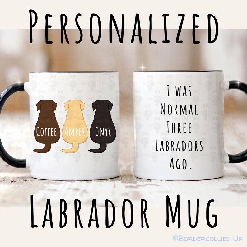 May include: White ceramic Labrador mug with black handle and rim. One side features three Labrador silhouettes in brown, yellow, and black, labeled "Coffee," "Amber," and "Onyx." The other side reads "I WAS NORMAL THREE LABRADORS AGO."