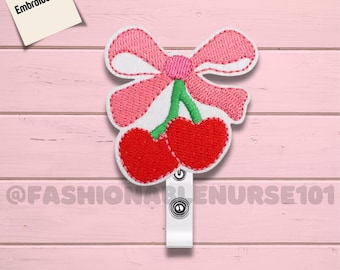 Porta badge con fiocco rosa ricamato e ciliegie, ideale per infermieri.