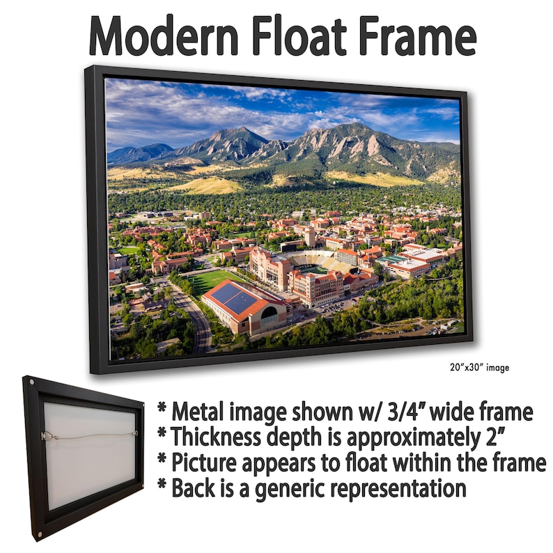 May include: A modern float frame displaying a scenic landscape of a city nestled at the foot of mountains under a blue sky. The frame is black, with a 3/4" wide frame and a thickness of approximately 2". The image size is 20"x30".