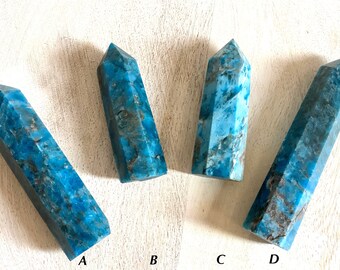 Könnte beinhalten: Vier blaue Apatit-Kristallspitzen, beschriftet mit A, B, C und D, auf einer weißen Holzoberfläche.