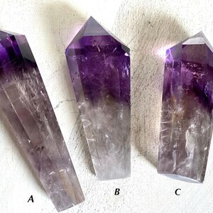 May include: Three amethyst crystal points with a gradient of purple and clear quartz. The points are labeled A, B, and C.