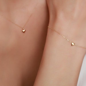 May include: A gold necklace and bracelet with small heart charms.