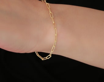 Peut inclure: Un bracelet en chaîne dorée avec un design simple et lié.