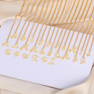 May include: A set of 26 gold-tone necklaces, each featuring a cursive letter charm. The letters range from A to Z.