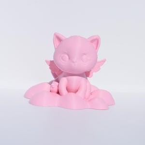 Könnte beinhalten: Eine rosa 3D-gedruckte Figur eines Katers mit Flügeln, der auf einer Wolke sitzt. Der Kater hat große Augen und einen süßen Ausdruck.