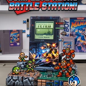 May include: A custom Game Boy Pocket console featuring a Mega Man graphic, mounted on a diorama base with pixelated character figures. The screen displays Tetris gameplay. Text includes "COMPLETE RETRO BATTLE STATION!" and "FULLY CUSTOM & TESTED | READY TO PLAY!"