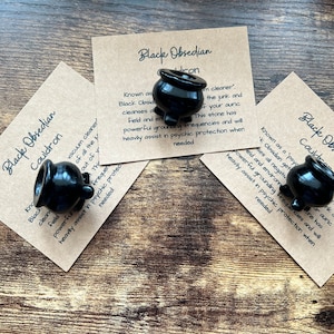 以下が含まれることがあります： 「ブラックオブシディアンケトル」と「すべてのゴミの掃除機として知られており、あなたのオーラフィールドと環境がネガティブな周波数で重くなっている場合、この石は強力な接地周波数を持っており、必要なときに精神的な保護に大いに役立ちます。」というテキストが書かれた、黒いオブシディアンのケトルチャームが3つあります。