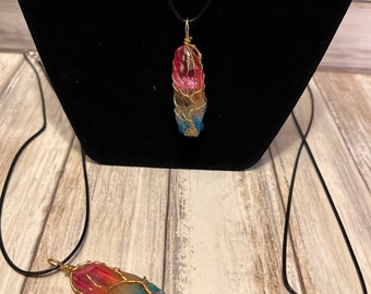 May include: Two necklaces with rainbow crystal pendants wrapped in gold wire. The crystals are a mix of pink, blue, and yellow.