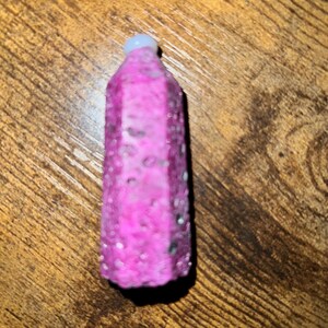 May include: A pink and white bottle stopper with a textured surface.