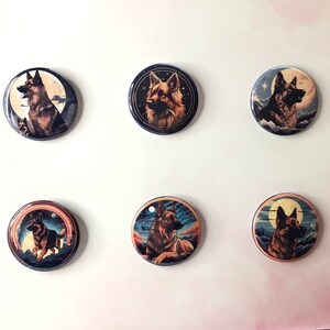 May include: Six circular pin-back buttons featuring artistic illustrations of German Shepherd dogs. Each button displays a unique scene with the dog set against backgrounds of moons, starry night skies, clouds, and colorful sunset-toned horizons.