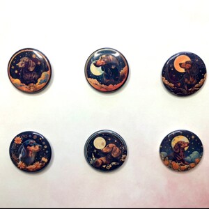 May include: A set of six circular pin-back buttons featuring illustrations of dachshund dogs. Each button displays a dark blue night sky background with stars, clouds, and a moon, surrounding a brown or black dachshund in various poses.
