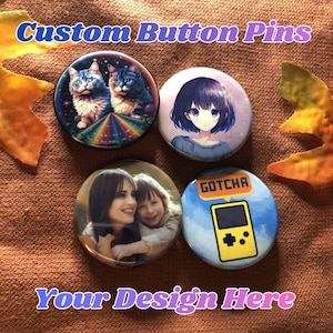 May include: Four custom button pins with various designs. One pin features two cats, another an anime-style girl, a third a photo of a mother and child, and the last a retro video game. The text "Custom Button Pins" and "Your Design Here" are visible.