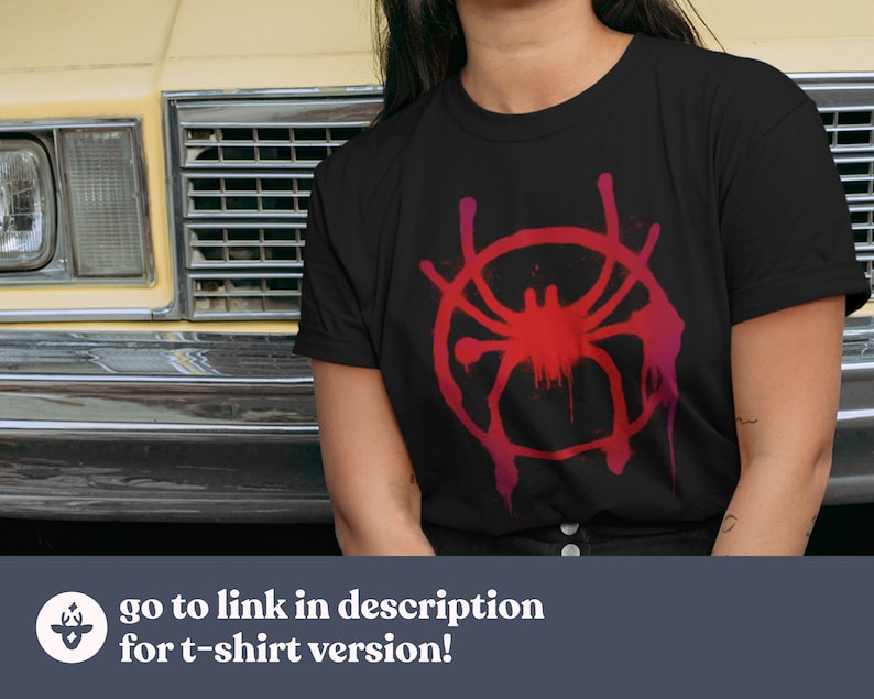 Puede incluir: Una camiseta negra con un gr&aacute;fico rojo y rosa del logotipo de Spider-Man: Into the Spider-Verse. El logotipo es una telara&ntilde;a estilizada con una ara&ntilde;a en el centro.