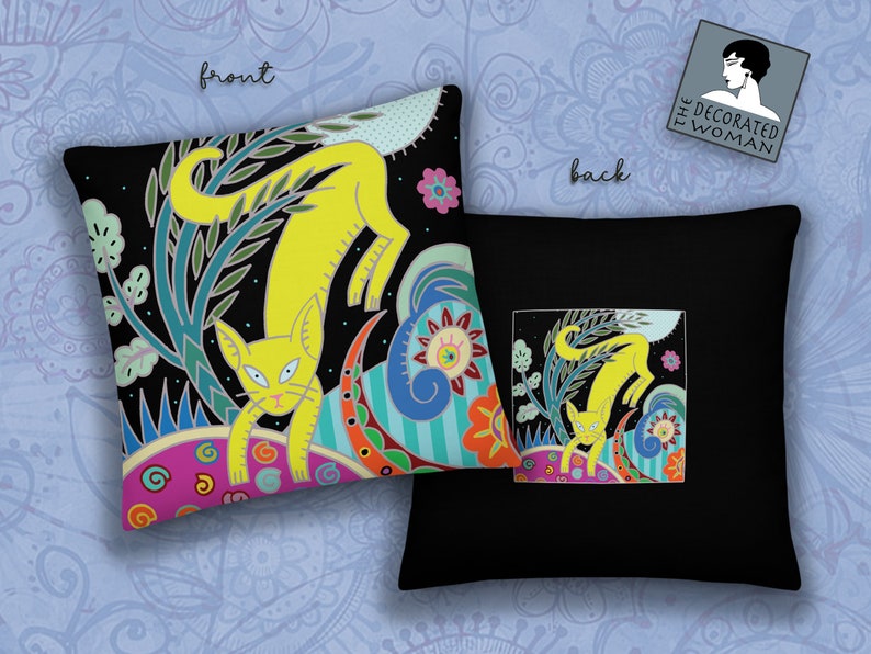 Peut inclure: Un oreiller noir avec un motif de chat jaune sur le devant et le dos. Le chat est entour&eacute; de fleurs et de feuilles color&eacute;es. Le texte "The Decorated Woman" est sur le dos de l'oreiller.