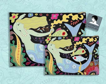May include: Two black zippered pouches with a colorful mermaid design. The mermaids are green with yellow hair and are surrounded by flowers, seaweed, and fish. The text "The Decorated Woman" is on the smaller pouch.
