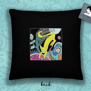 Peut inclure: Un oreiller noir avec une illustration color&eacute;e d'un chat jaune dans un jardin fantaisiste. Le texte "The Decorated Woman" est sur une &eacute;tiquette blanche dans le coin sup&eacute;rieur droit.