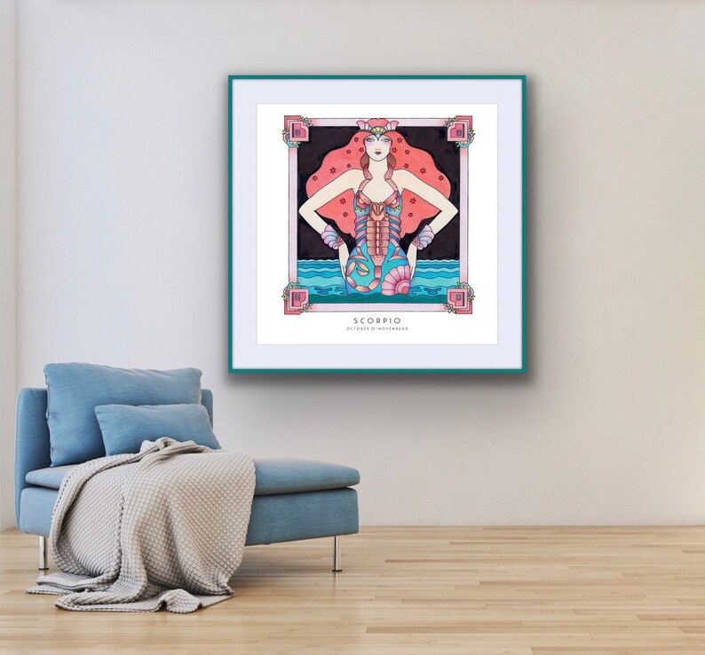 May include: A framed illustration of the zodiac sign Scorpio. The illustration features a woman with red hair and a blue and pink scorpion tail. The background is a dark blue with pink stars. The text "Scorpio" and "October 23 - November 21" is printed below the illustration.